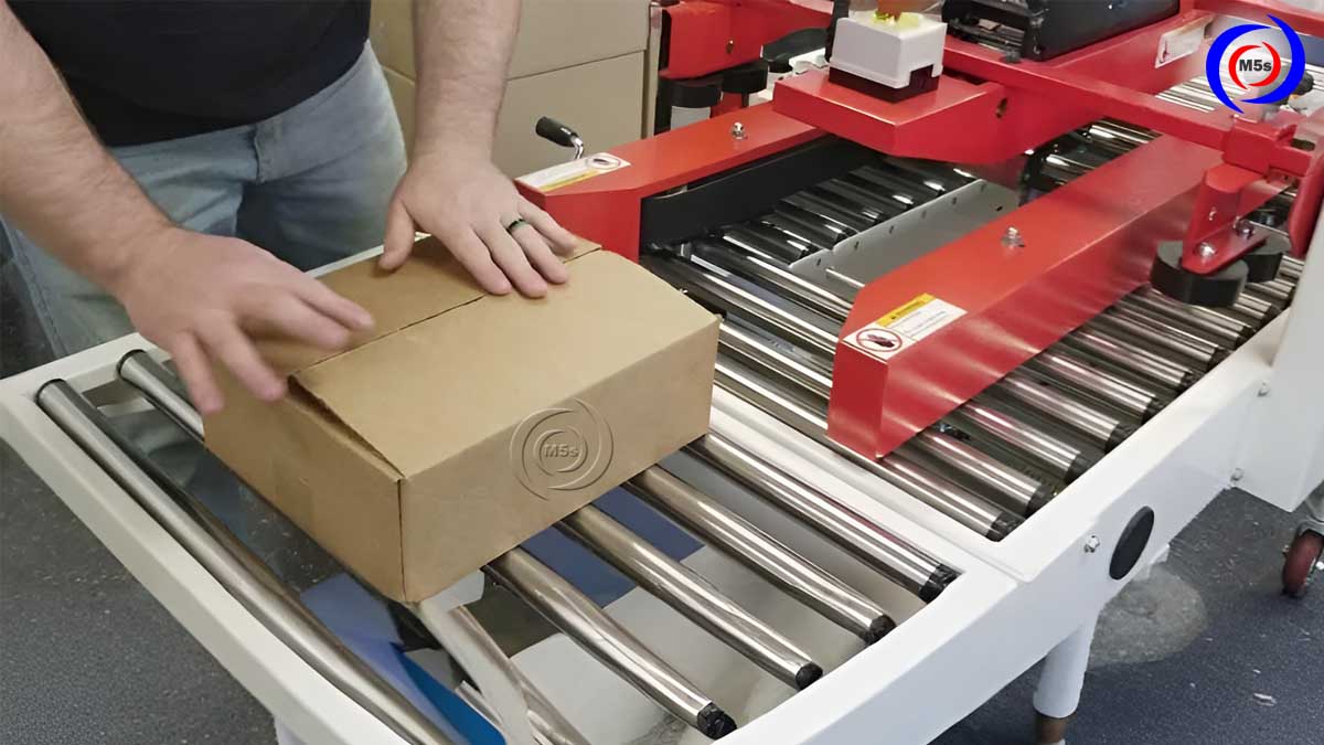 Nhân viên vận hành máy dán băng keo thùng carton